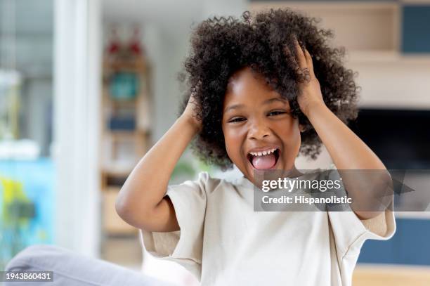 excited girl laughing at home - curly hair stock pictures, royalty-free photos & images