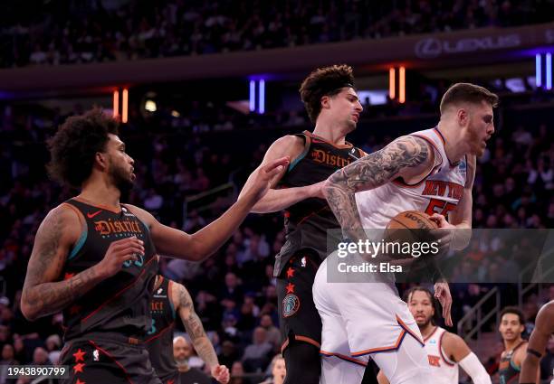 Isaiah Hartenstein of the New York Knicks grabs the rebound before Marvin Bagley III and Deni Avdija of the Washington Wizards at Madison Square...