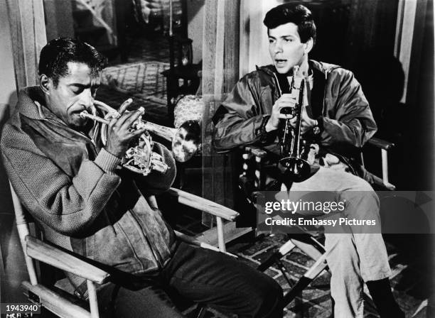 American singers and actors Sammy Davis Jr. , and Frank Sintra Jr. Practice trupets in a still from the film, 'A Man Named Adam,' directed by Leo...