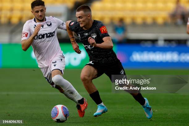 Jake Brimmer of the Victory and Benjamin Old of the Phoenix compete for the ball during the A-League Men round 13 match between Wellington Phoenix...