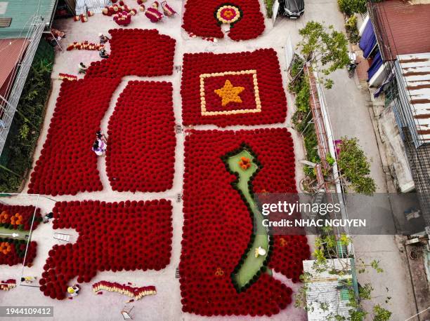 In this aerial photo taken on January 20, 2024 tourists pose in front of incense sticks arranged in the form of a Vietnamese map and flag in a...