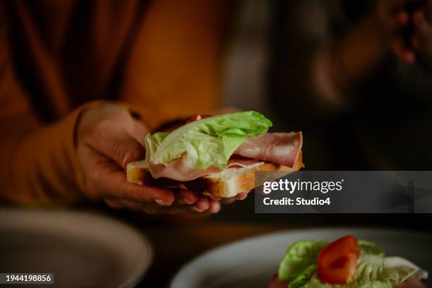 female hand holding a fresh sandwich - bread love stockfoto's en -beelden