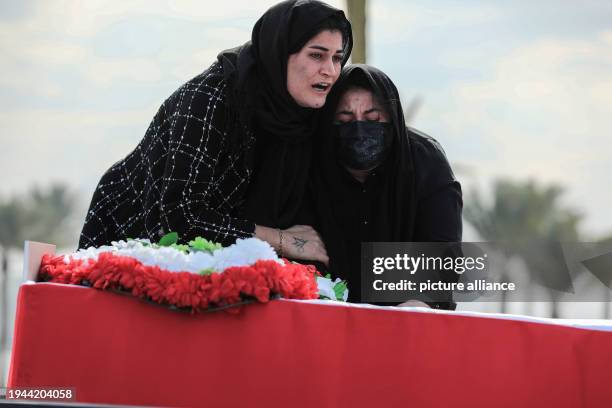 January 2024, Iraq, Baghdad: Relatives cry as the remains of 41 Yazidis, who were found in a mass grave in the Sinjar district, are transported...