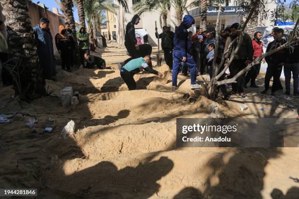 Relatives and loved ones of the Palestinians, who got killed during Israeli attacks, bury the bodies in the yard of Nasser Hospital since they cannot...