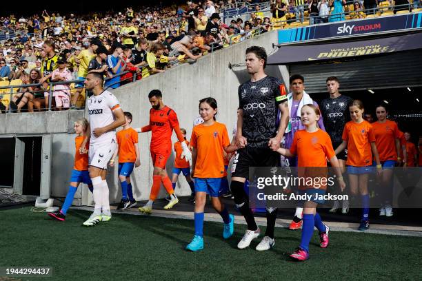 Captains Roderick Miranda of the Victory and Alex Rufer of the Phoenix lead their teams onto the pitch prior to the A-League Men round 13 match...