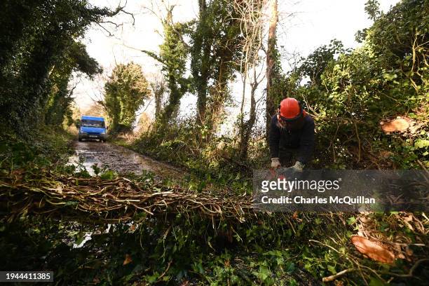 Tree surgeon is pictured at work on a blocked road on January 22, 2024 in Antrim, Northern Ireland. Much of the UK was battered overnight by Storm...