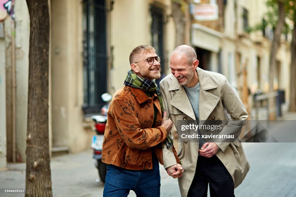Verspieltes schwules männliches Paar, das in der Stadt spazieren geht
