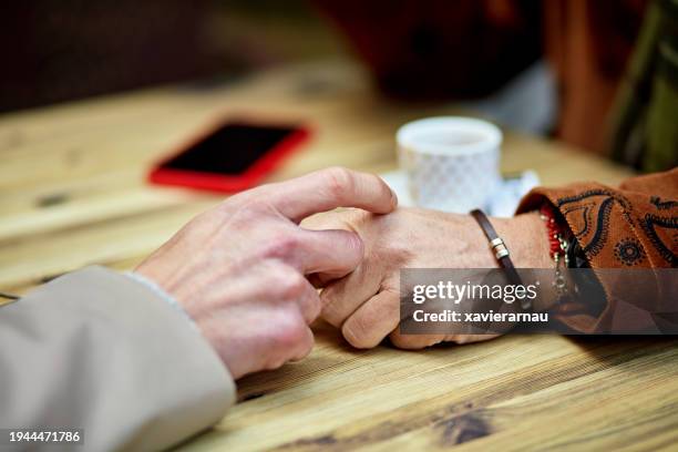 primer plano de manos masculinas maduras que descansan sobre la mesa de la cafetería - hombre gay fotografías e imágenes de stock
