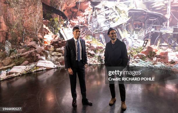 Britain's Prime Minister Rishi Sunak stands with graduate student Cody Updegrave in front of a digital image back drop projected onto a "Virtual...