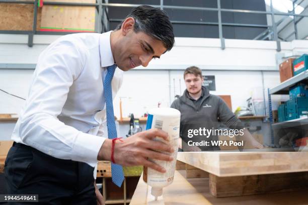 British Prime Minister Rishi Sunak helps to make a wooden door with carpentry apprentice Adam Jellis during a visit to Pinewood Studios on January...