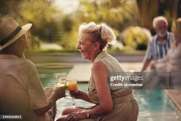 cheerful mature couple toasting by the pool in summer day. - retirement party stock pictures, royalty-free photos & images