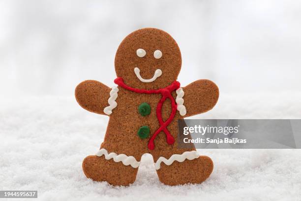 gingerbread man on snow - gingerbread biscuit stock pictures, royalty-free photos & images