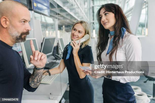 airport staff members talking with passengers at terminal gate - mature man smiling 40 44 years blond hair stock pictures, royalty-free photos & images