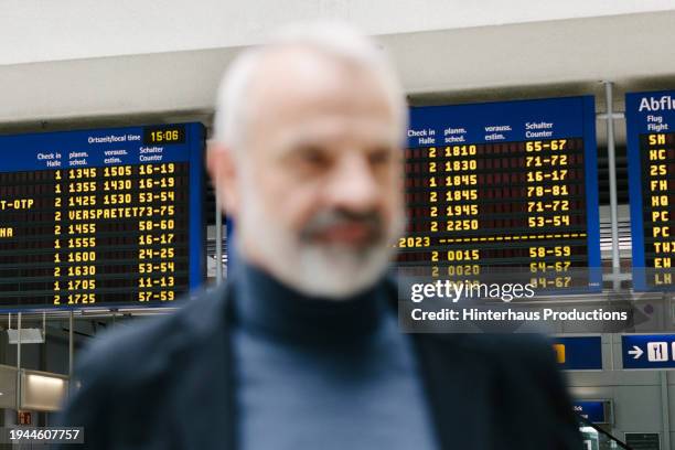 blurred image of a man standing in an airport - fokus-auf-den-hintergrund stock-fotos und bilder