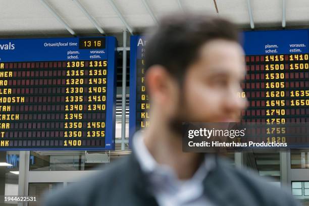 a busy airport terminal flight board - fokus-auf-den-hintergrund stock-fotos und bilder
