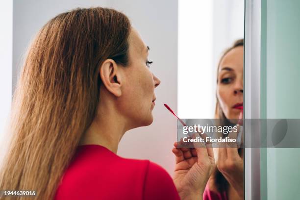 a woman getting dressed in red costume. - wishful skin imagens e fotografias de stock