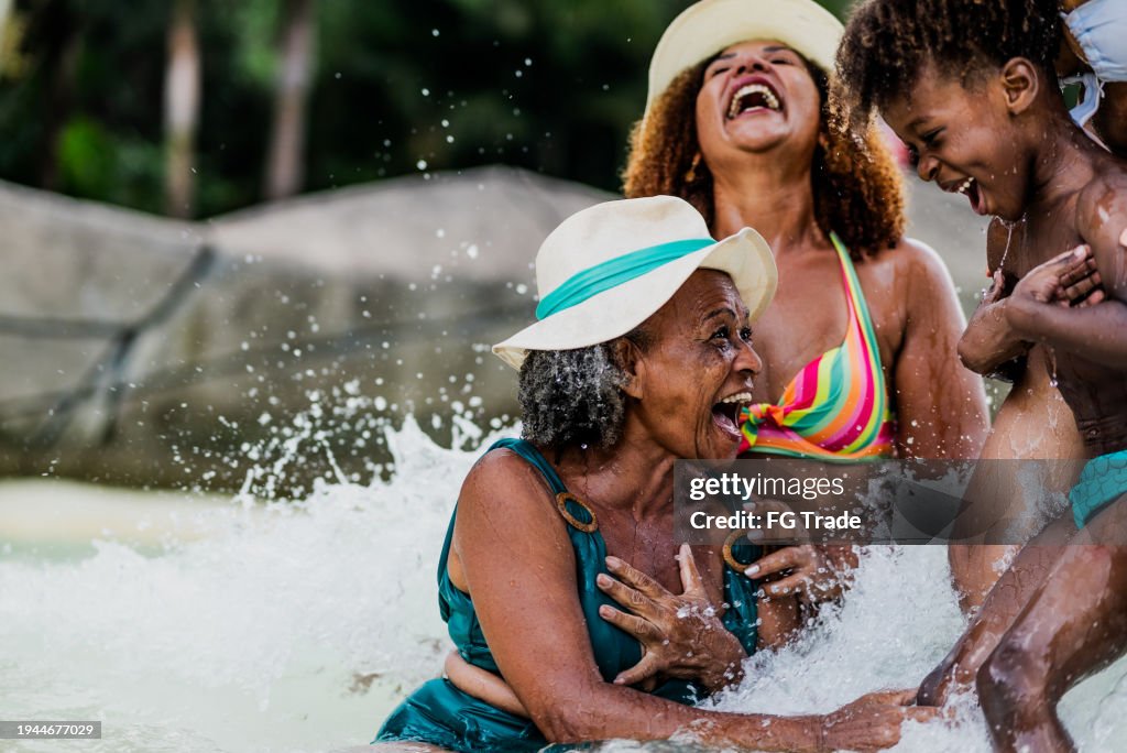 Family playing at water park pool