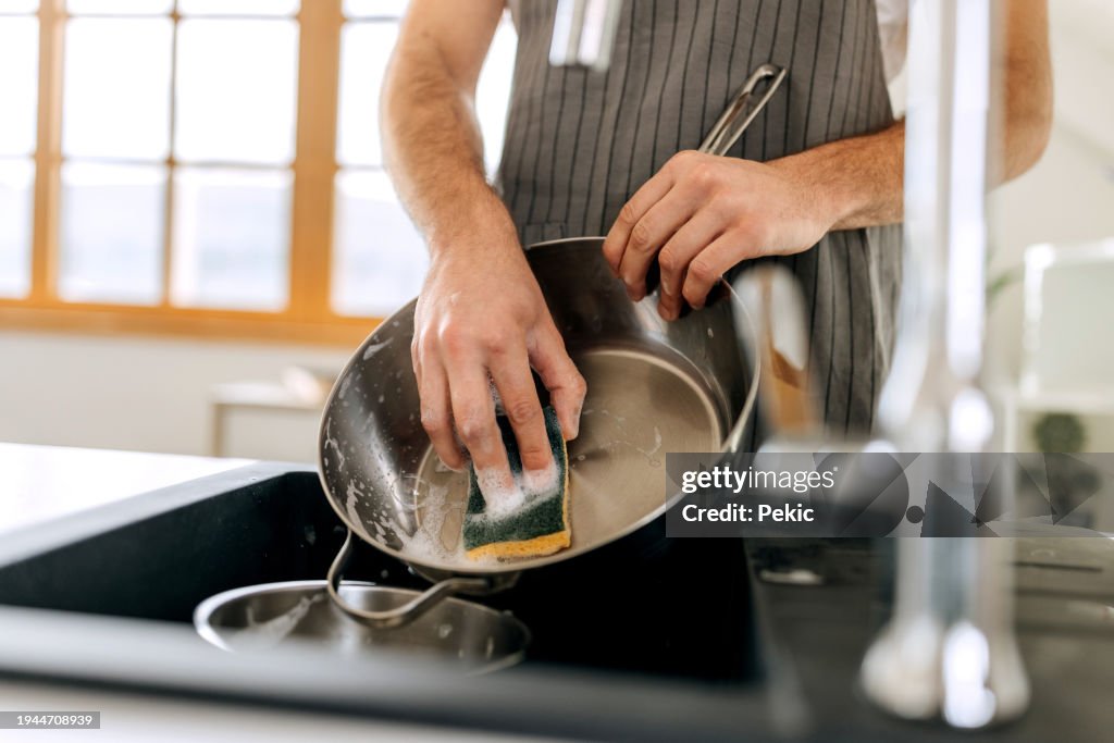 Close up shot of man washing cooking pan