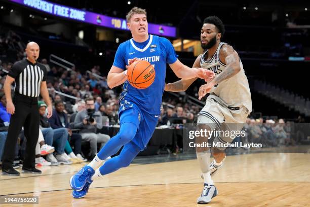 Baylor Scheierman of the Creighton Bluejays dribbles by Dontrez Styles of the Georgetown Hoyas during a college basketball game at the Capital One...