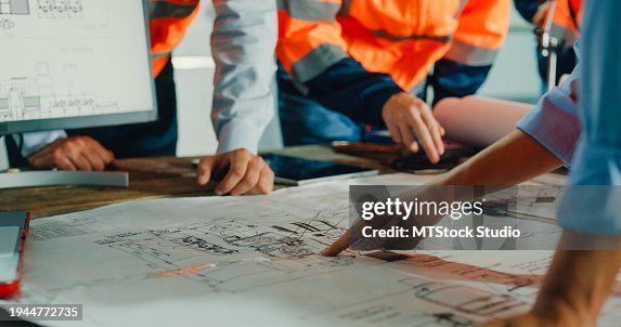 Primo piano del team di ingegneri industriali che si incontrano, analizzano i progetti dei macchinari, consultano il progetto sul tavolo nella fabbrica di produzione. Lavorare in un impianto di produzione o in un impianto di produzione. Primo piano del team di ingegneri industriali che si incontrano, analizzano i progetti dei macchinari, consultano il progetto sul tavolo nella fabbrica di produzione. Lavorare in un impianto di produzione o in un impianto di produzione.