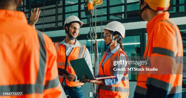 team of industrial engineers meeting analyze machinery blueprints consult project on laptop in manufacturing factory. engineering and sustainable production plant. - health and safety stock pictures, royalty-free photos & images