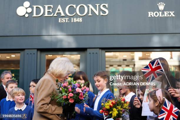 Britain's Queen Camilla receives get well cards for Britain's King Charles III during a visit to Deacon & Son Jewellers in Swindon, western England...