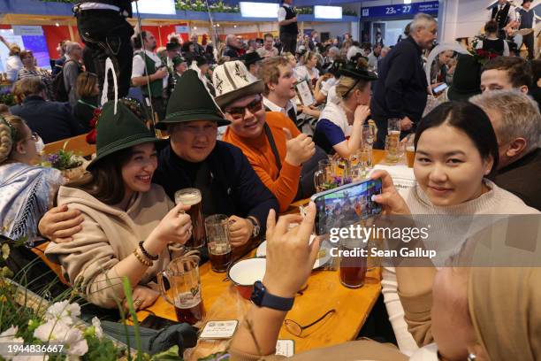 Visitors from Kyrgyzstan go local and enjoy beer in the Bavaria hall at the Green Week agricultural trade fair on its opening day on January 19, 2024...