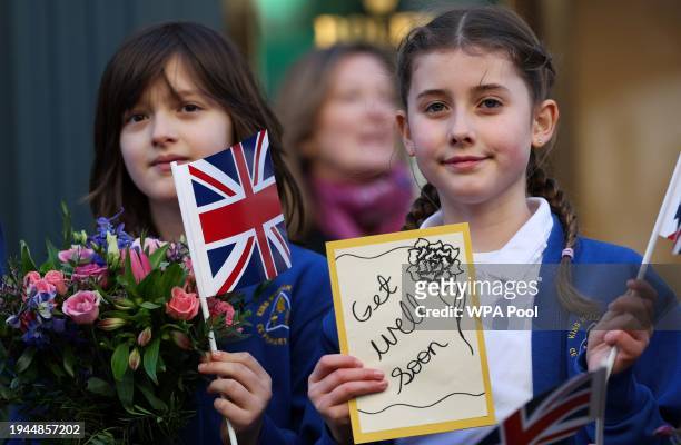 Group of young girls hold get well cards for Britain's King Charles III as they wait to greet Britain's Queen Camilla during her visit to Deacon &...