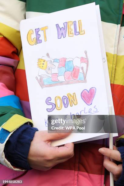 Young girl holds a get well card for Britain's King Charles III as she waits to greet Britain's Queen Camilla during her visit to Deacon & Son...