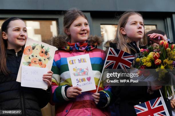 Group of young girls hold get well cards for Britain's King Charles III as they wait to greet Britain's Queen Camilla during her visit to Deacon &...
