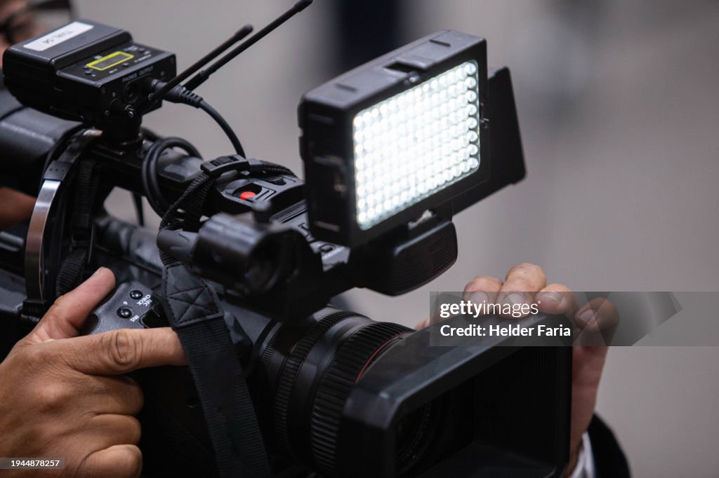 Detail of a cameraman operating/filming a TV camera with LED lighting attached