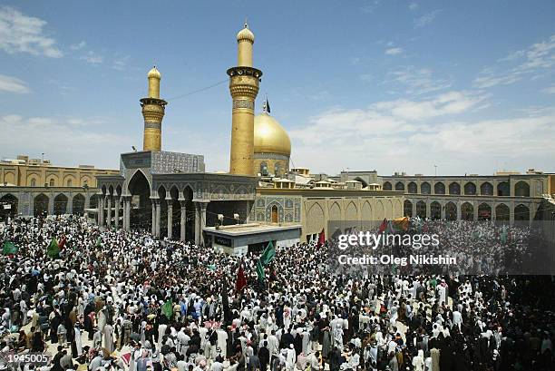 Iraqi Shiite men walk around the mosque of Imam Hussein April 22, 2003 a holy shrine in the center of Karbala, Iraq. Iraqi Shiite Muslims traveled to...