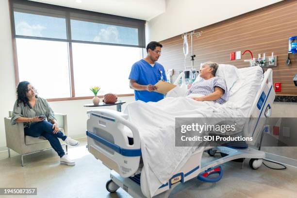 adult daughter listens carefully while the surgeon talks with her mom - casualty stock pictures, royalty-free photos & images