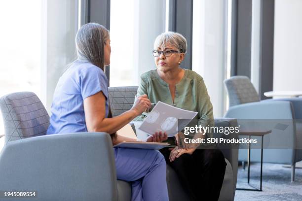 female surgeon talks to woman about possible brain cancer - neurologist stock pictures, royalty-free photos & images