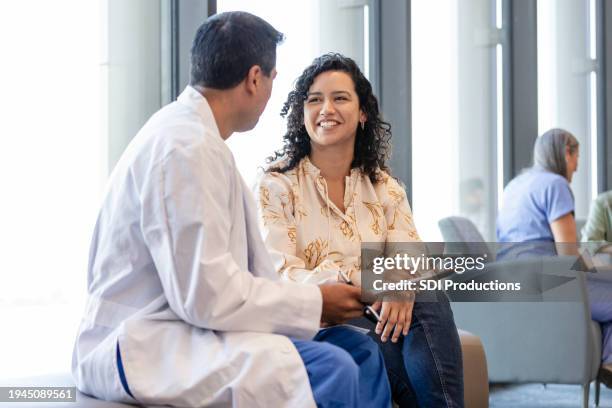 female family member gets good news from male surgeon - patient good news stock pictures, royalty-free photos & images