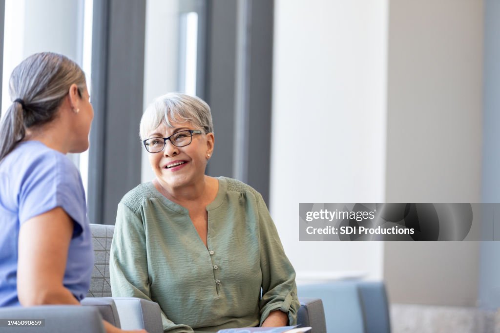 Senior adult woman smiles while talking to her doctor