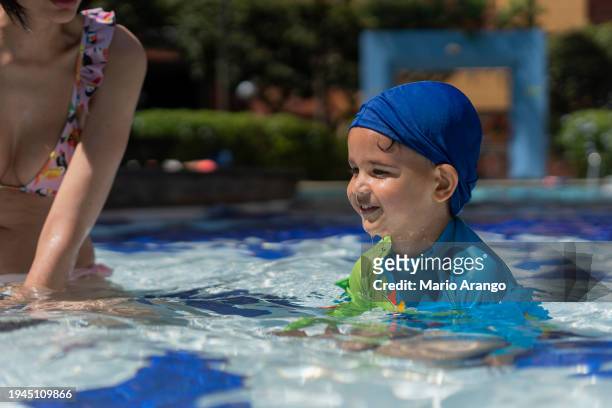 latin children are in the pool enjoying a beautiful day with the family - mario bros stock pictures, royalty-free photos & images