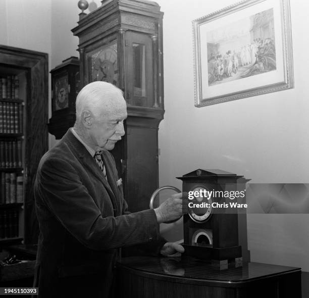 George St Vincent, 5th Baronet Harris , winding a decimal time clock by Janvier at Belmont House in Faversham, Kent, February 1971.
