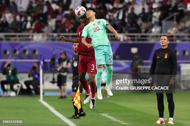 China's Serbian coach Aleksandar Jankovic looks on as his forward Wei Shihao vies for a header against Qatar's defender Al-Mahdi Ali Mukhtar during...