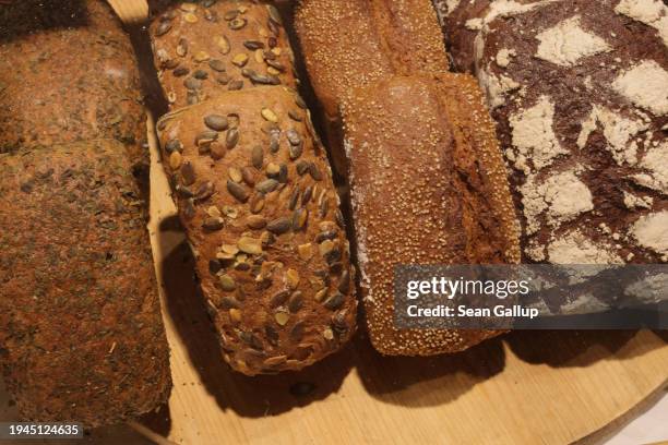 Whole grain loaves of bread lie on display behind glass at the Green Week agricultural trade fair on its opening day on January 19, 2024 in Berlin,...