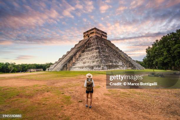 woman admiring chichen itza's kukulkan pyramid at sunrise, mexico - old ruin stock pictures, royalty-free photos & images