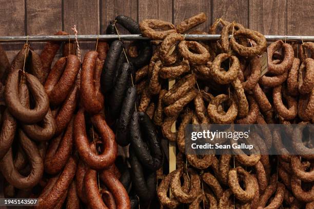 Sausages hang on display at a meat products stand at the Green Week agricultural trade fair on its opening day on January 19, 2024 in Berlin,...