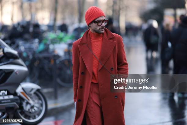 Fashion Week Guest is seen wearing a full red outfit, long wool jacket, a red turtleneck pullover, red boots, a red hat and darkred glasses during...