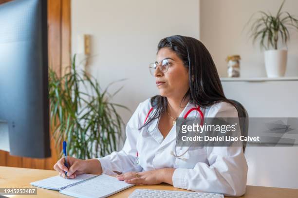 female doctor taking notes in her notebook - casa calvet stock pictures, royalty-free photos & images