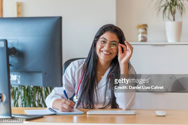 female doctor sitting at desk in office - casa calvet stock pictures, royalty-free photos & images