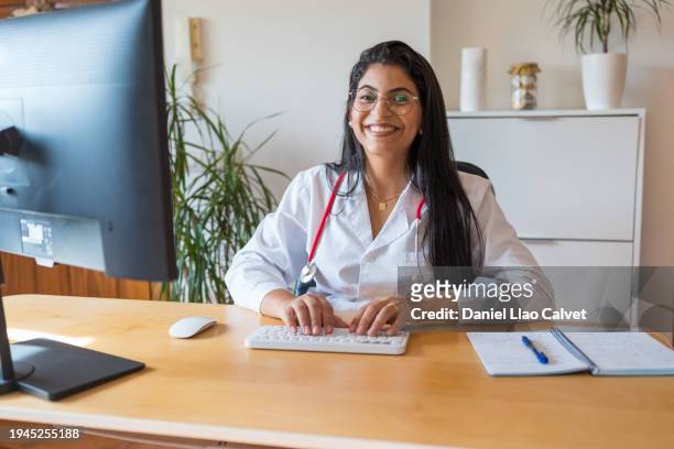 female doctor sitting at working desk - casa calvet stock pictures, royalty-free photos & images