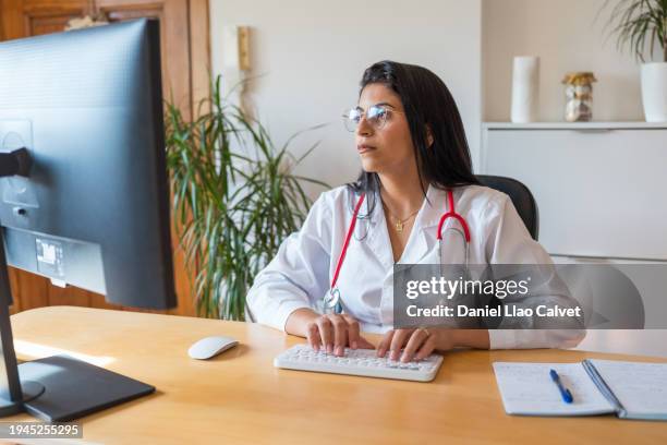 female doctor using laptop working from home - casa calvet stock pictures, royalty-free photos & images