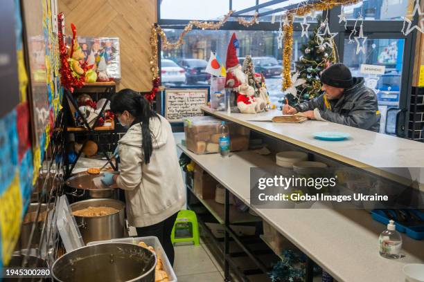 Man writes a review in the Book of Reviews in the volunteer ‘FuMi Caffe’ cafe on December 1, 2023 in Kharkiv, Ukraine. A Japanese volunteer Fuminori...