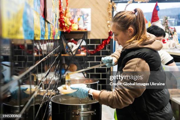 Worker pours a free lunch to a visitor of the volunteer ‘FuMi Caffe’ cafe on December 1, 2023 in Kharkiv, Ukraine. A Japanese volunteer Fuminori...