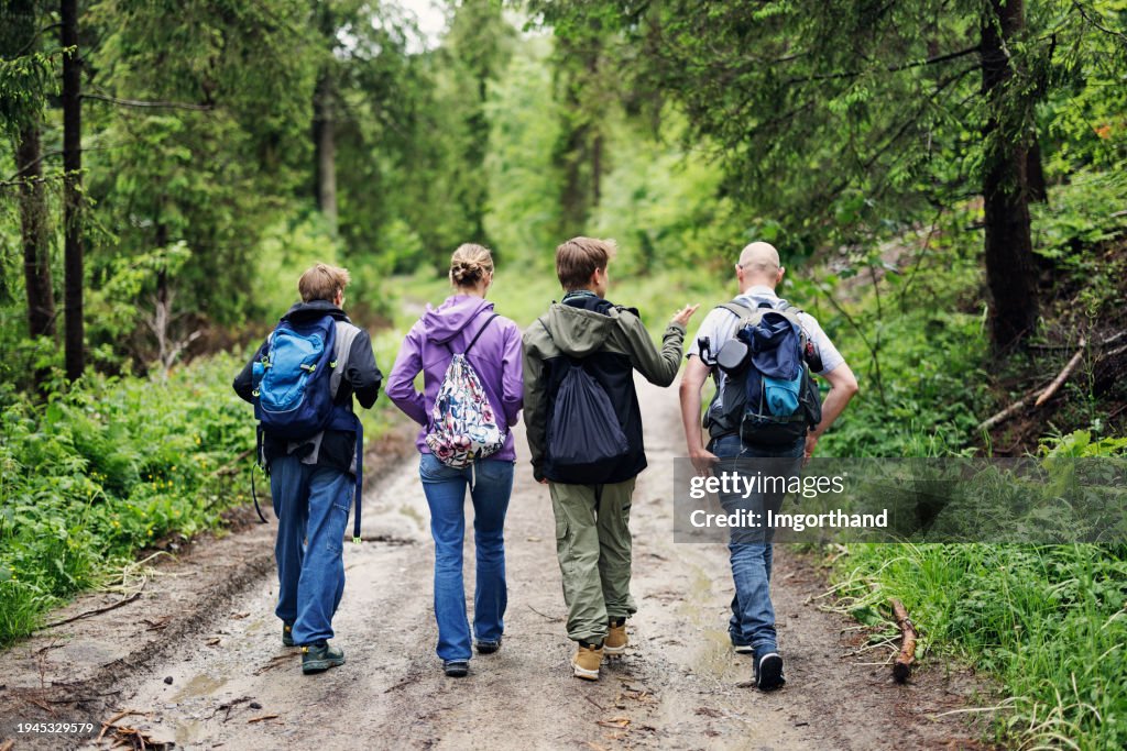 Father and teenage kids hiking in Beskid Sądecki mountain range in Poland